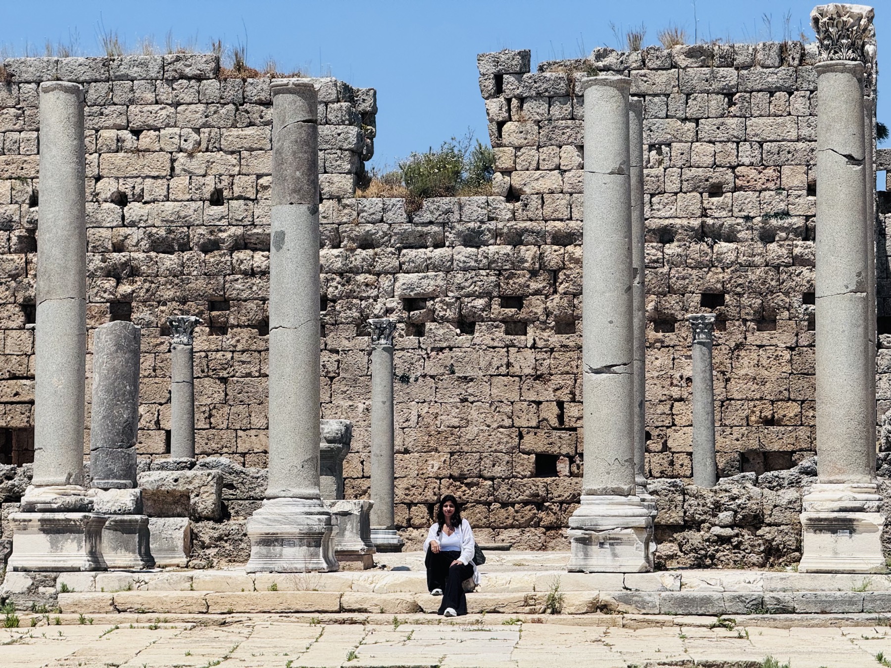 Veda sitting among ancient columns at Perge