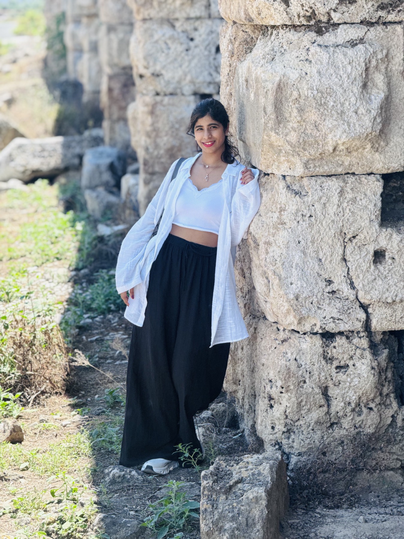 Veda beside the stone wall of the stadium at Perge